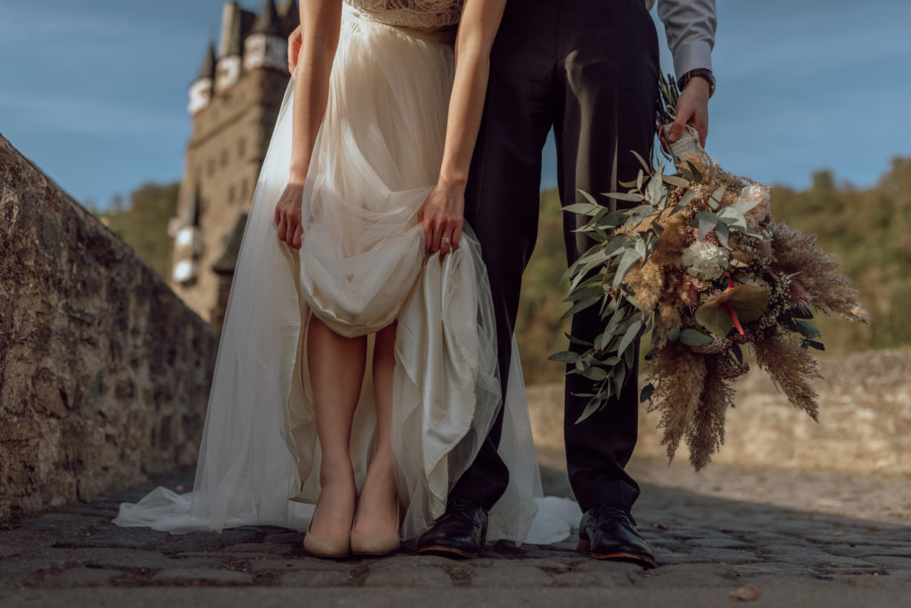 wedding photos at burg Eltz in Germany couple poses with their shoes
