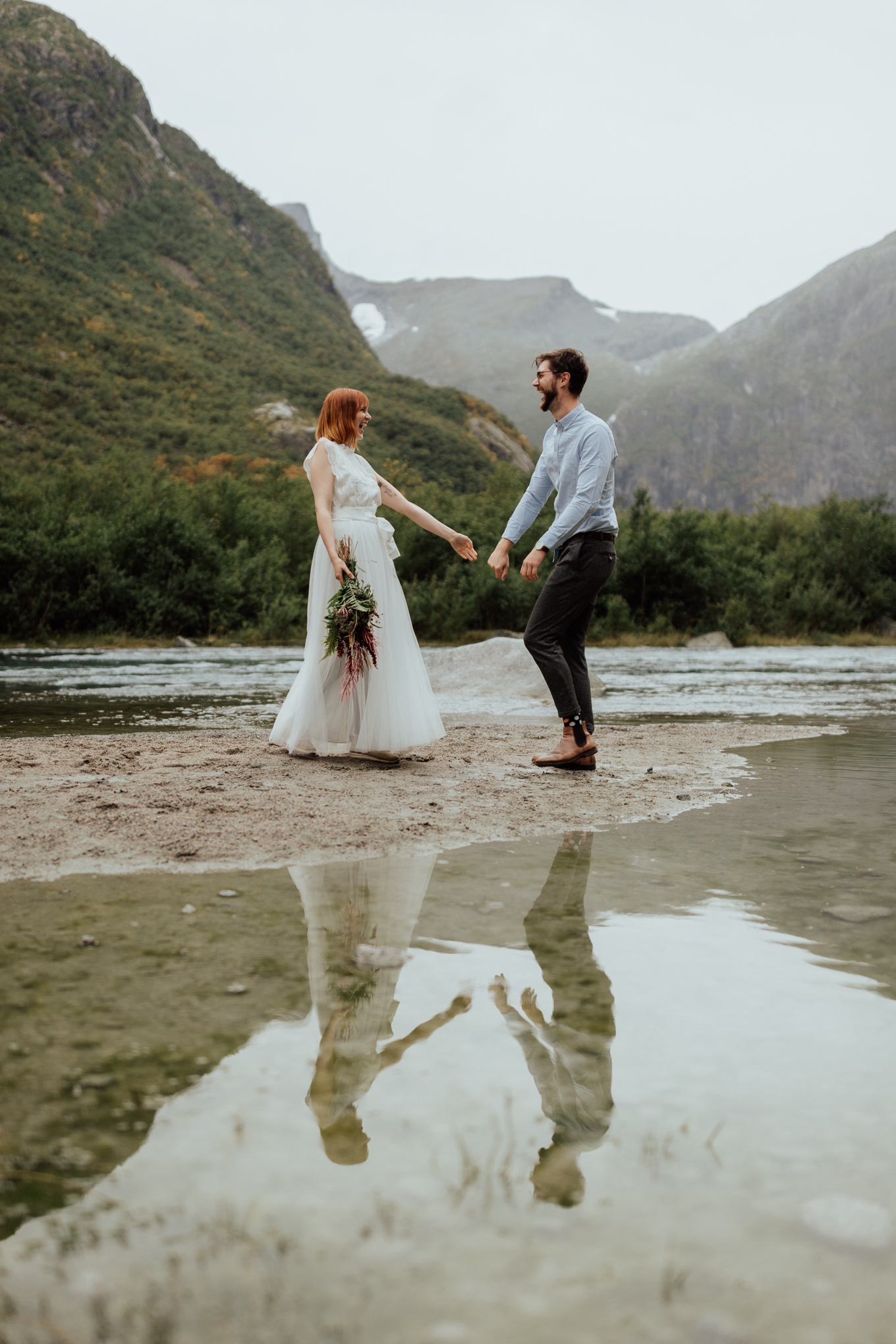 A couple dances and laughs during their Norway elopement at a glacial lake