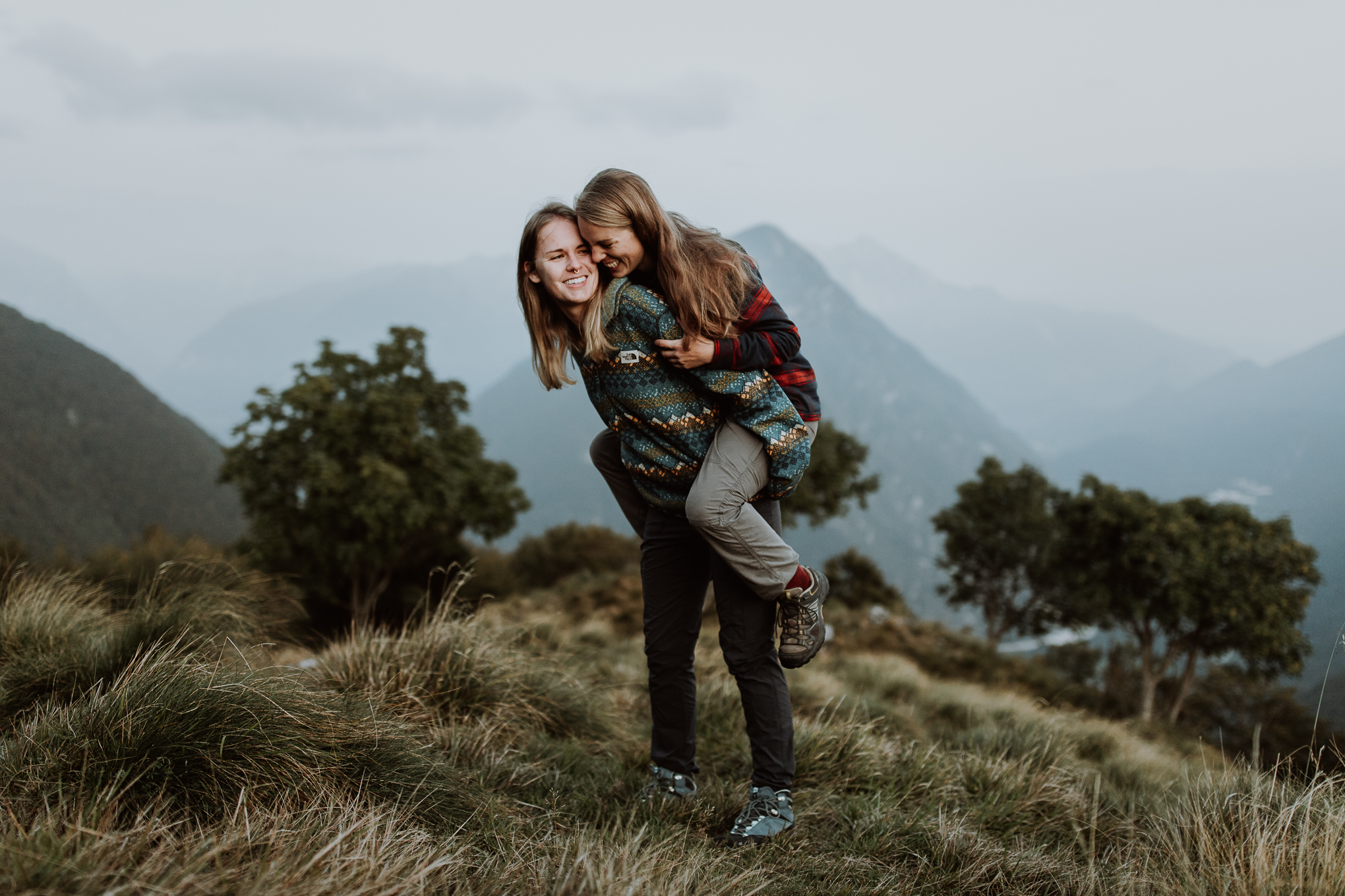 lesbian couple plays during their elopement shoot in the Slovenian alps