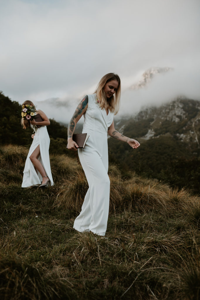 A lesbian couple walks down the trail near Triglav national park as part of their Slovenia elopement photography adventure.
