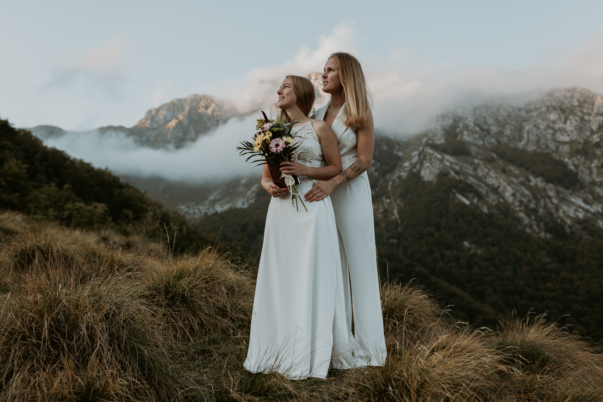 A couple elopes in Slovenia near the Soca River with the Slovenian Alps in the background. Slovenia elopement photography inspiration.