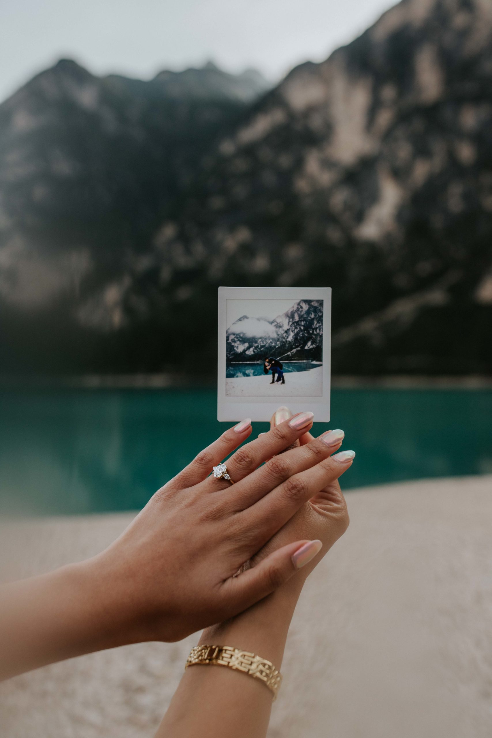 couple gets engaged at Lago di Braies and shows off their wedding ring and polaroid photos
