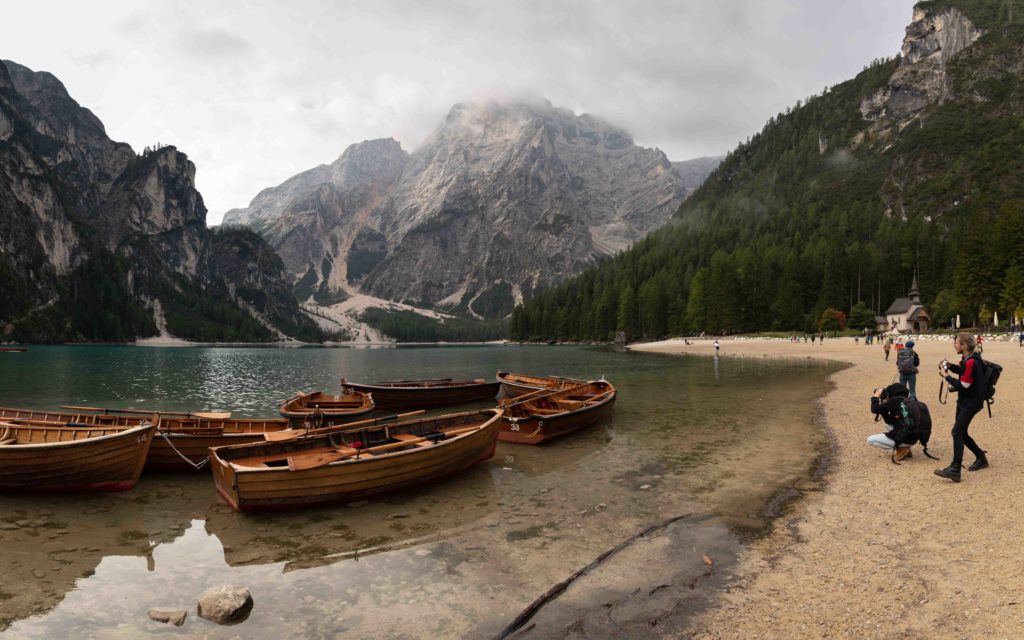 A group of photographers photograph the famous wooden boats at Lago di Braies.