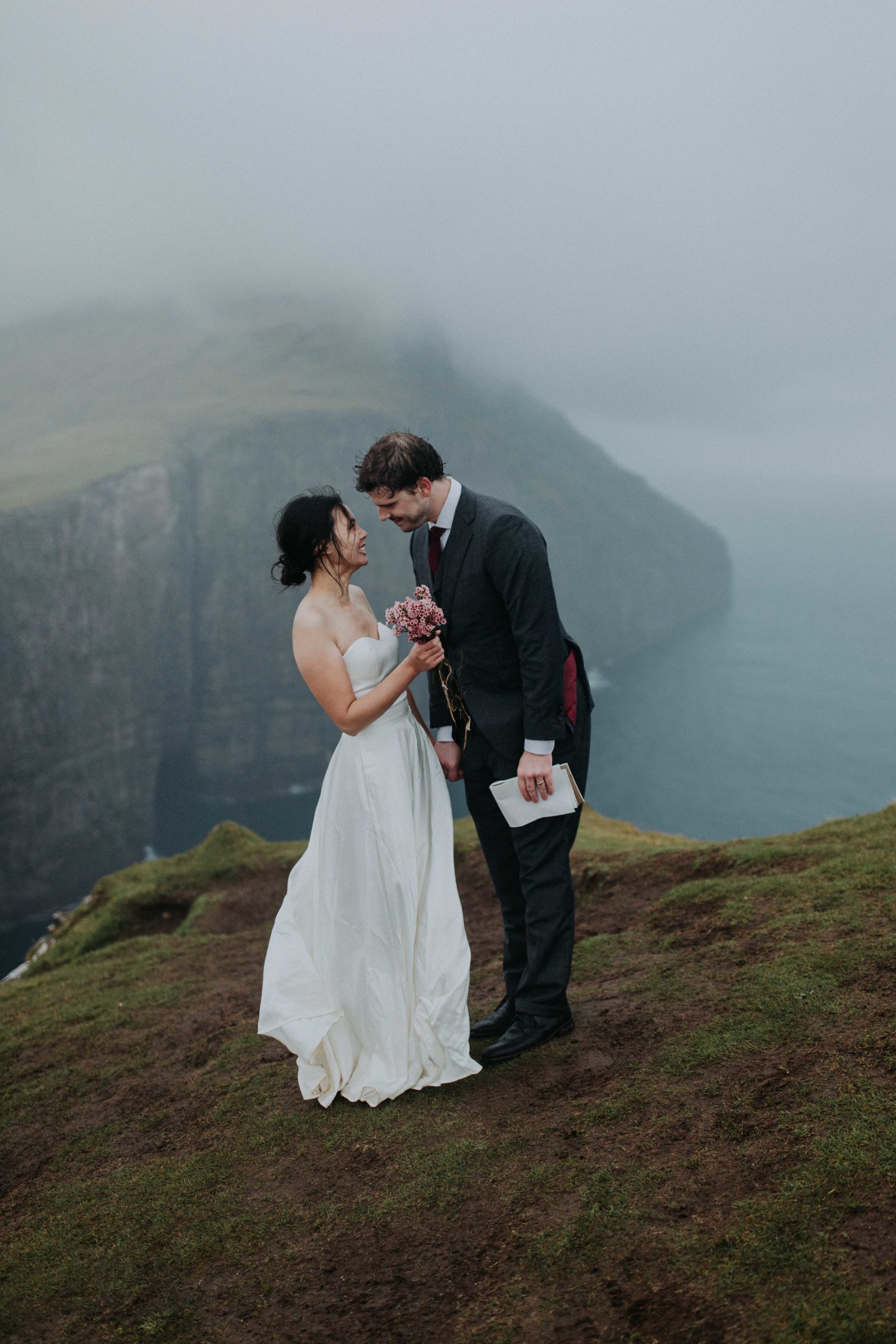 Couple reads their vows above Slave Cliff near Sorvagsvatn in the Faroe Islands on their elopement day.