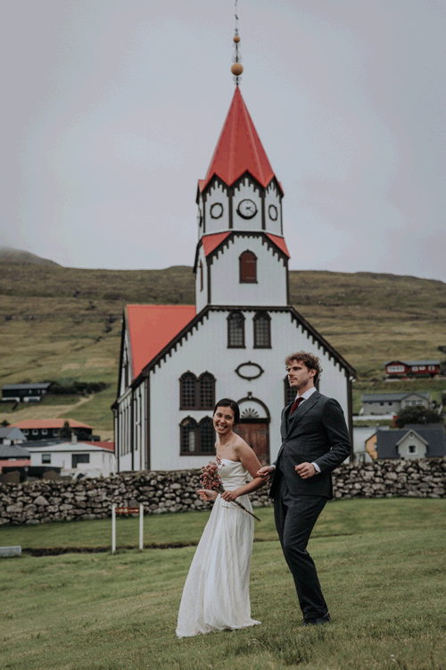 Couple dances near a church in the Faroe islands during their elopement.