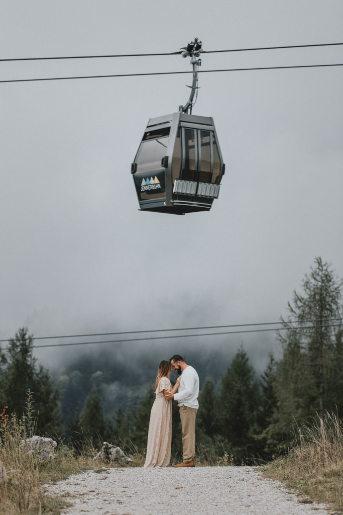 Couple stands forehead to forehead under Jenneralm cable car during their October vow renewal in Berchtesgaden, Germany