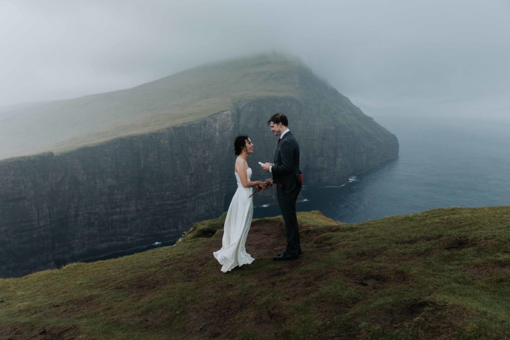 A couple says their vows near a steep sea cliff on the Faroe Islands.