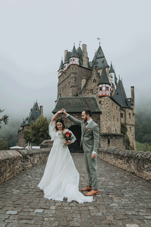 This is a gif of a wedding couple dancing outside a castle during their elopement in Europe. 
