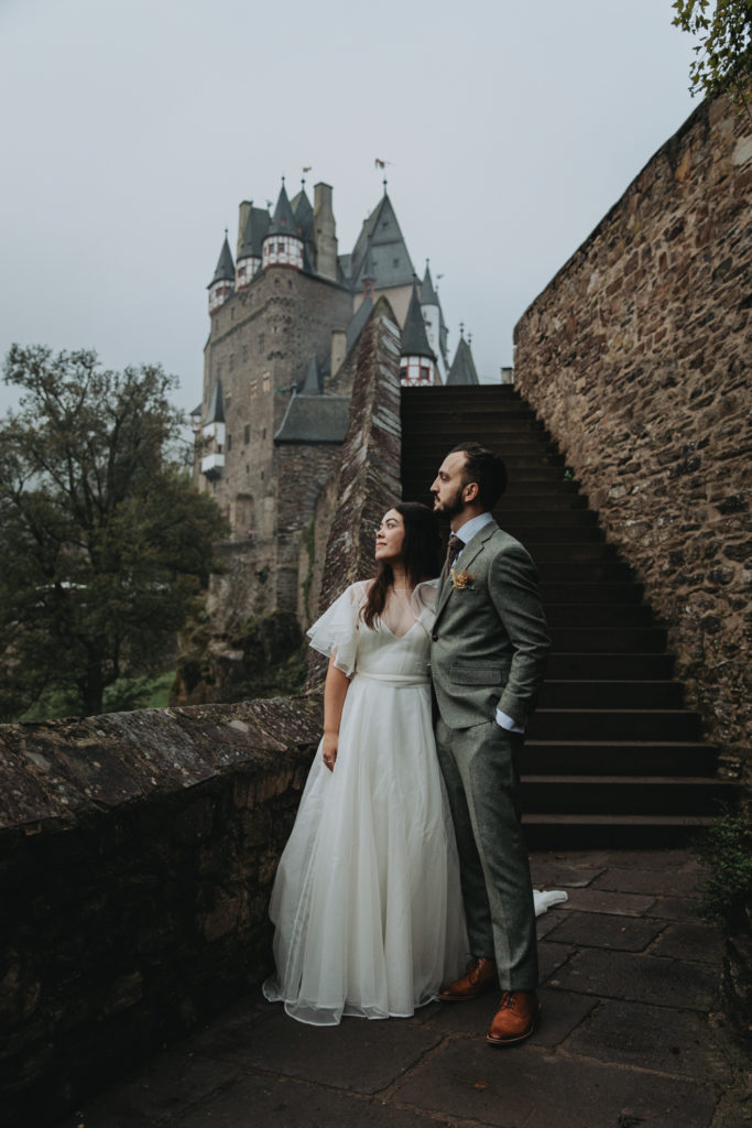 Couple stands shoulder to shoulder during their elopement outside Burg Eltz in Germany