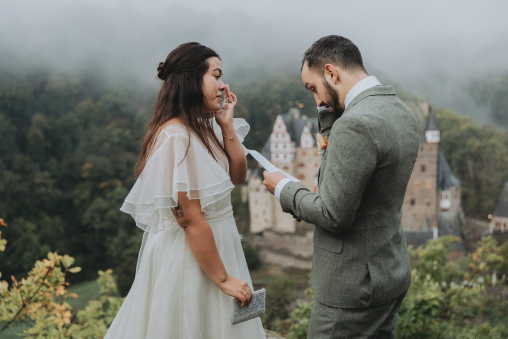 Couple reads vows for their elopement outside Burg Eltz in Germany