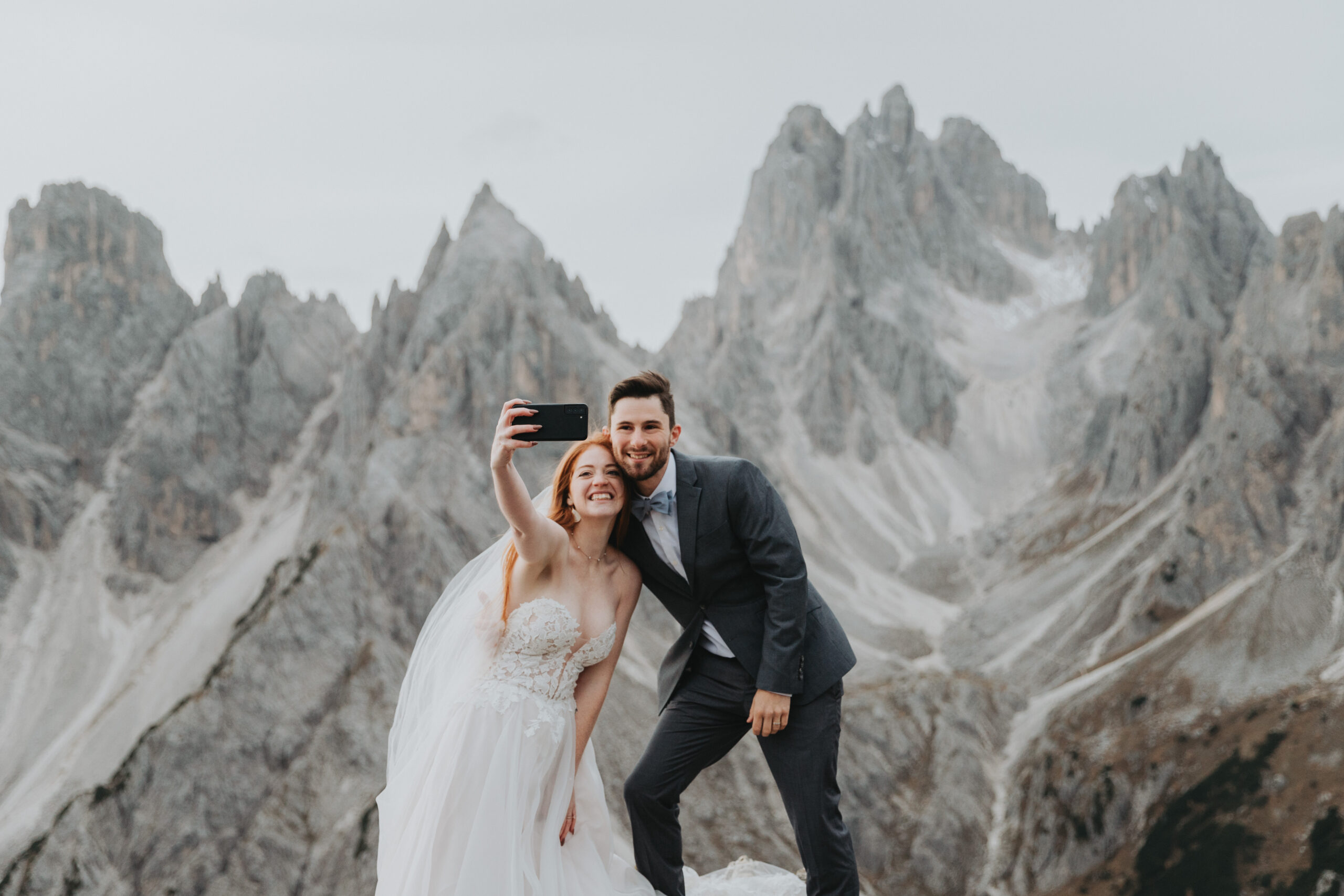 A couple poses for a selfie while they're eloping at Cadini di Misurina, an impressive mountain peak in the Italian Dolomites