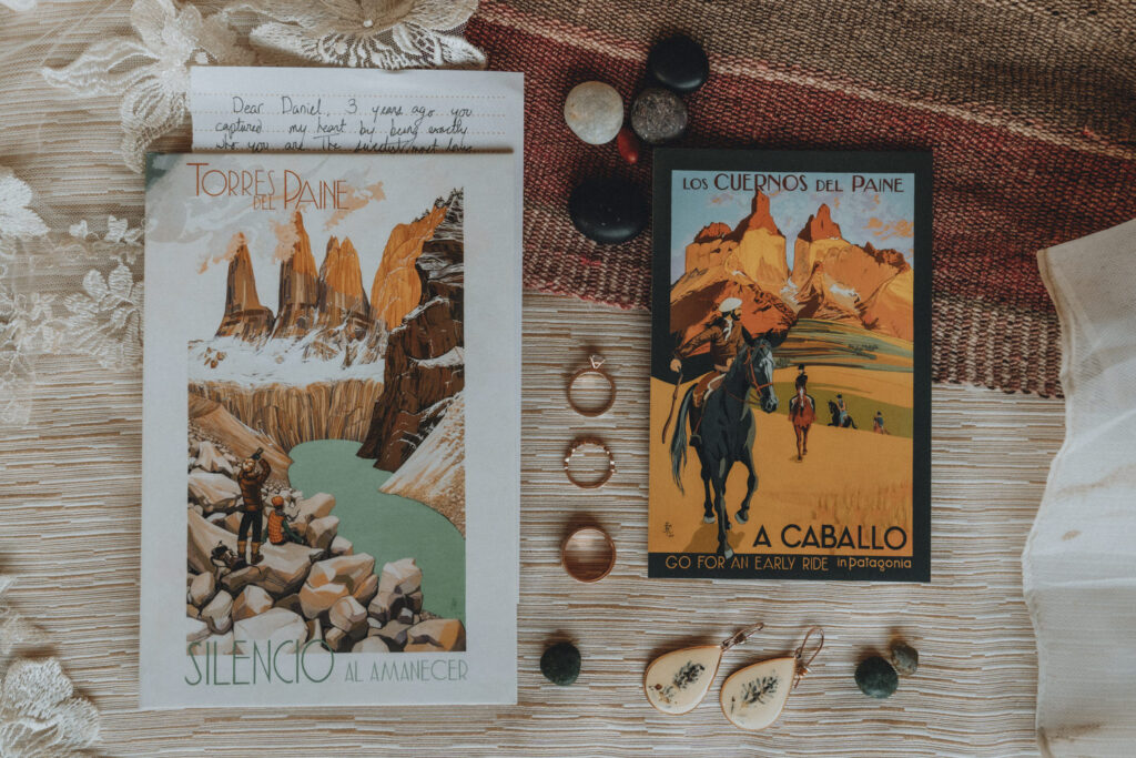 An arrangement of postcards, vow books, rings, jewelry and wedding clothes during an elopement day in Patagonia.
