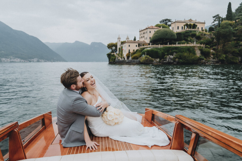 A couple embrach on the back of a wooden motor boat during their elopement day in the European Alps