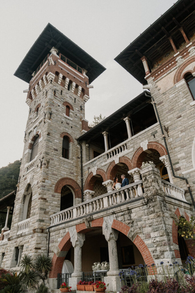 A couple stand far in the photo, framed by the geometric architecture of Villa Pessina, a popular location on Lake Como for photos.
